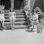 grayscale photo of 2 women riding on bicycle