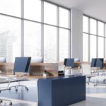 A panoramic view shows an empty commercial office space filled with desks, empty chairs, and computers.