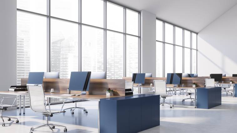 A panoramic view shows an empty commercial office space filled with desks, empty chairs, and computers.